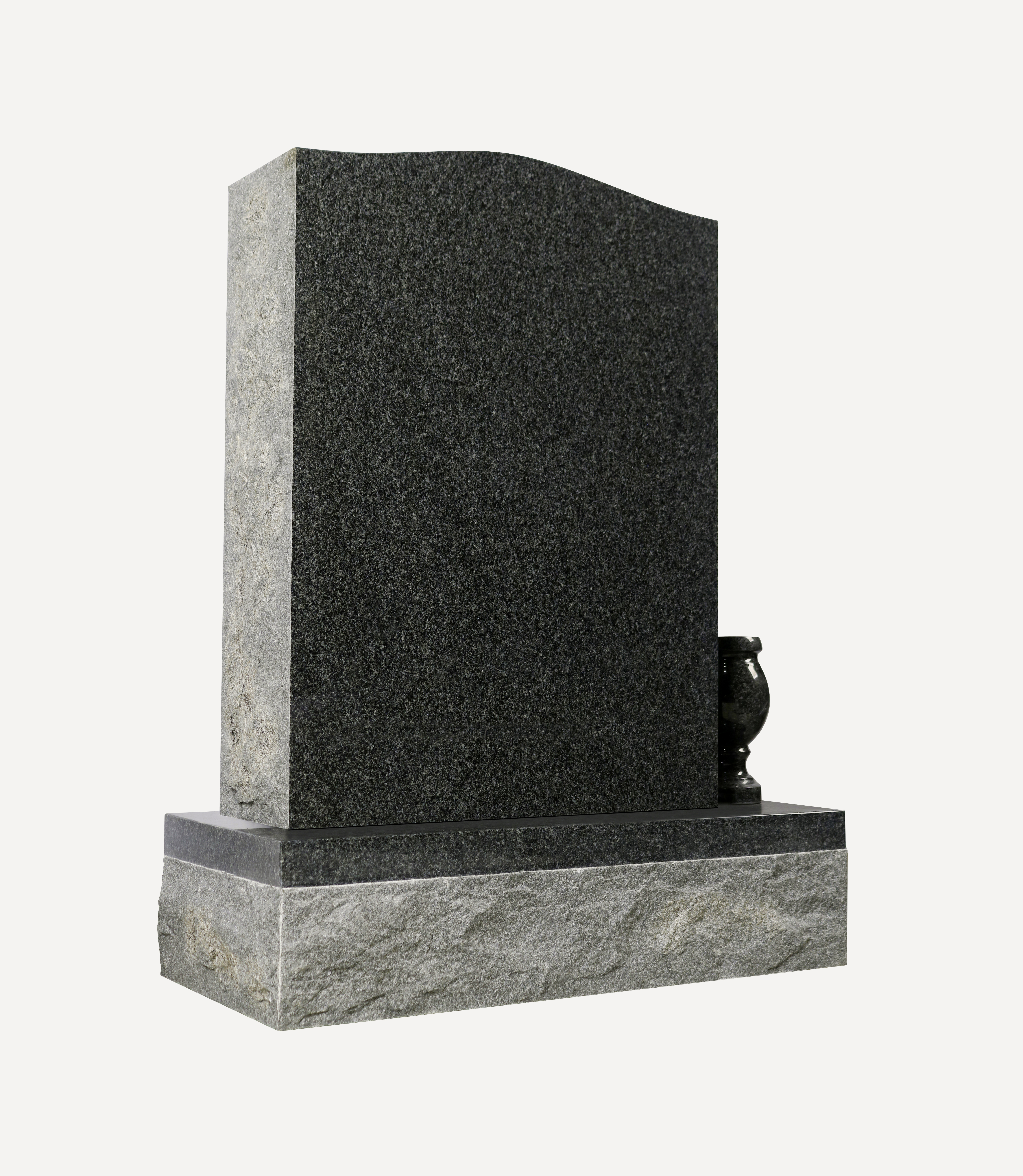 A modern upright headstone crafted from dark gray speckled granite, featuring a gently curved top edge and a polished base. A small, matching granite vase sits on the right side of the base, elegantly contrasting with the rougher texture of the lower foundation.