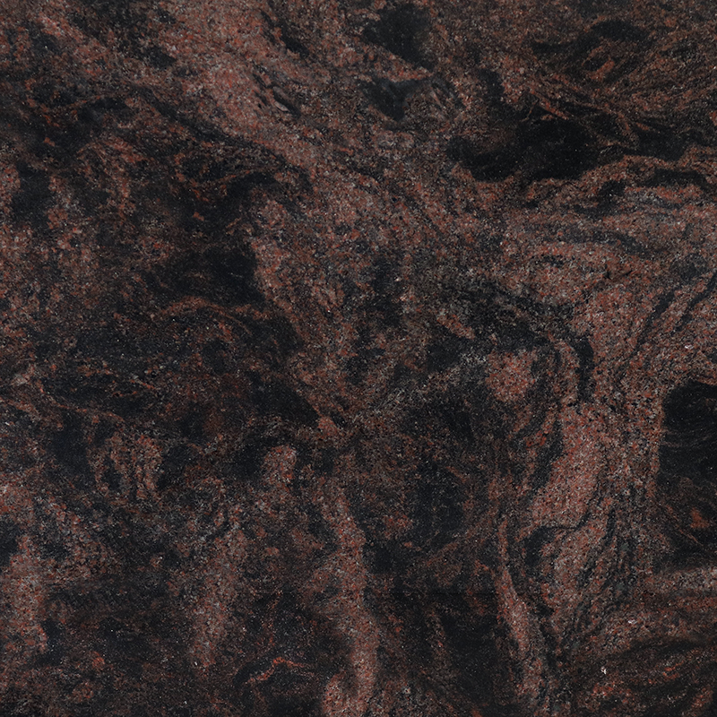 A close-up image of Cosmic Black granite, showcasing its dark, near-black coloration with dynamic reddish-brown veins and specks creating a swirling, natural pattern. This intricate stone texture is often chosen for its durability and unique aesthetic in memorial and headstone designs.