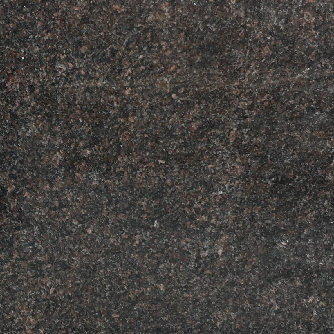 A close-up image of a dark brown granite surface showing its rough, speckled texture with various shades of brown and black. This realistic stone texture is ideal for memorial artwork backgrounds.