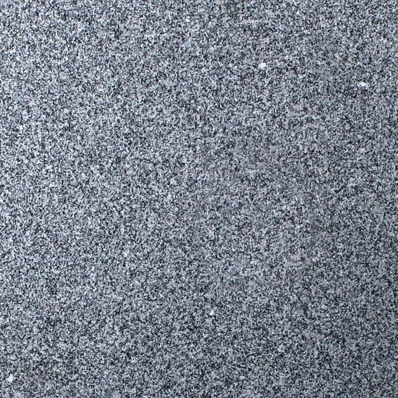A close-up image of a speckled grey granite stone surface, showing a fine grain with irregular flecks of black, white, and various shades of grey. This robust texture is commonly used for headstones and memorials, conveying durability and a natural aesthetic.