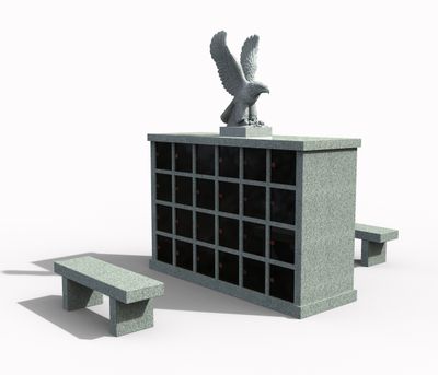 A detailed granite columbarium with multiple dark niches, topped by a powerful eagle sculpture with wings spread. Two matching granite benches are placed on either side, creating a complete and serene cremation memorial setting.